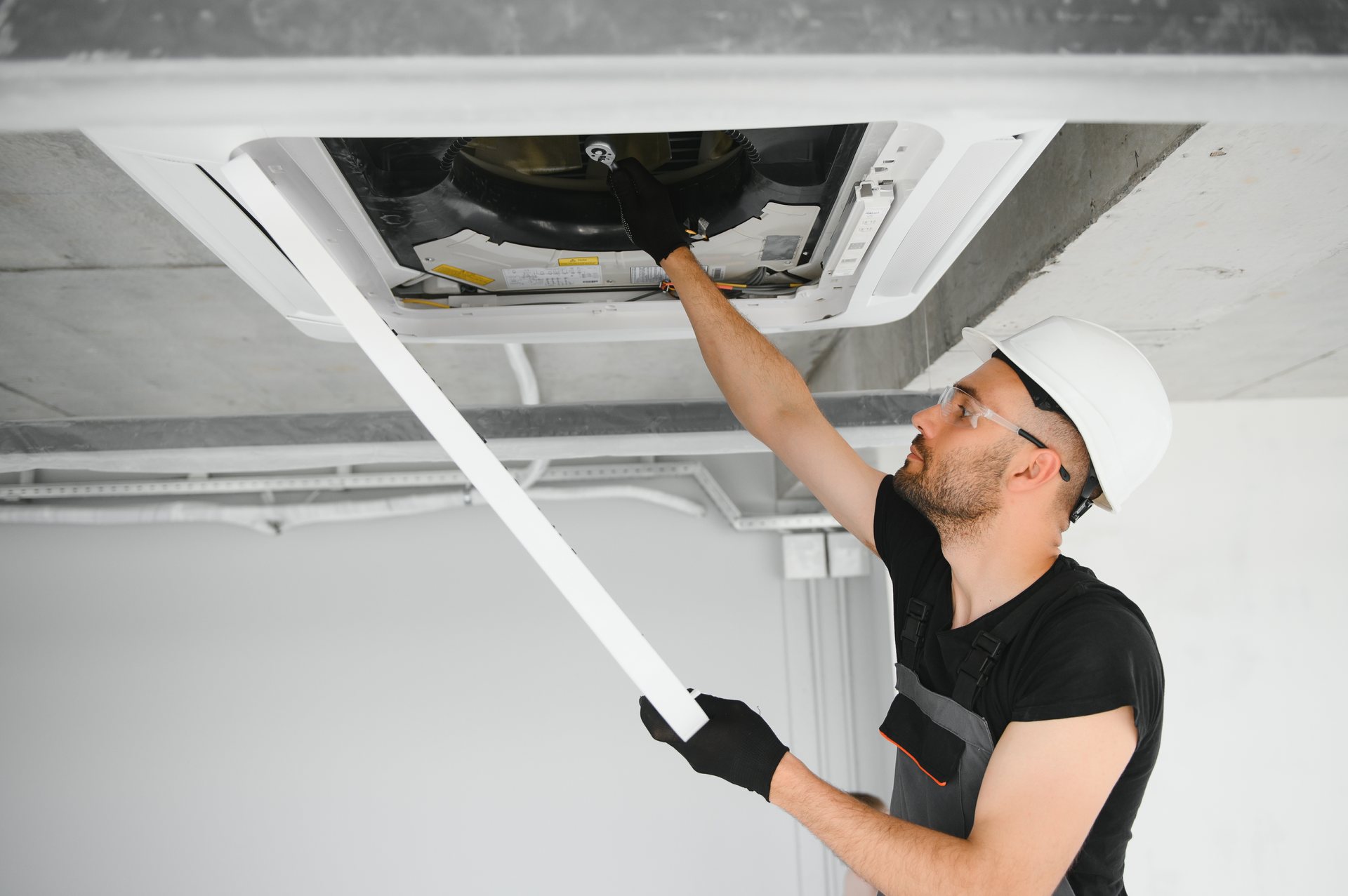 Techniker bei der Reinigung einer Lüftungsanlage an der Decke